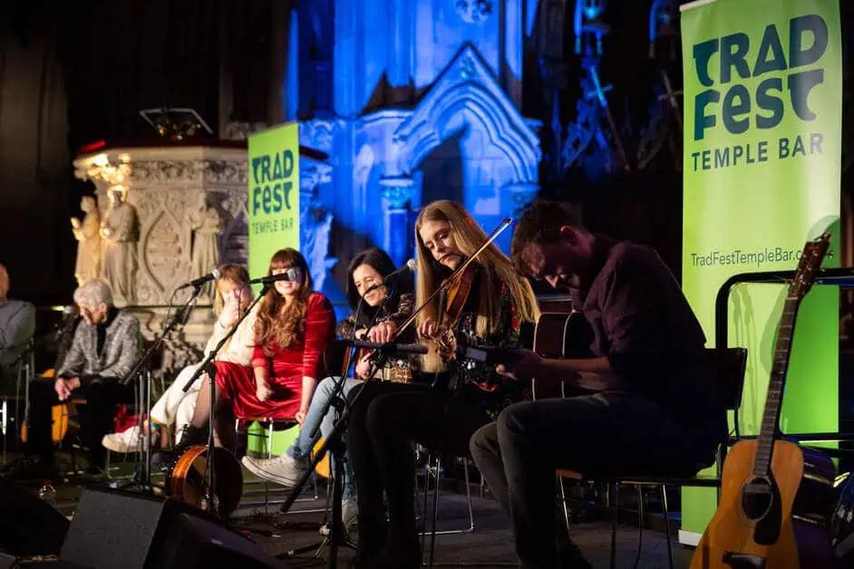 Womenn of Note, Frauen mit Streichinstrumenten auf der Bühne, dahinter die grünen Banner des Dubliner TradFest