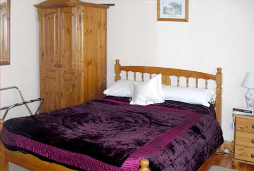 Schlafzimmer mit Doppelbett aus hellem Holz
